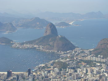 High angle view of city by sea against sky