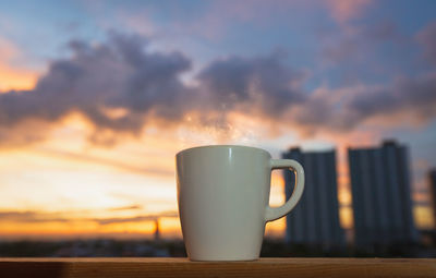 Close-up of coffee on table against sky during sunset