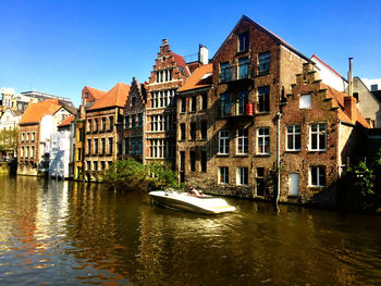 Canal amidst buildings against sky