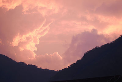 Low angle view of silhouette mountain against dramatic sky