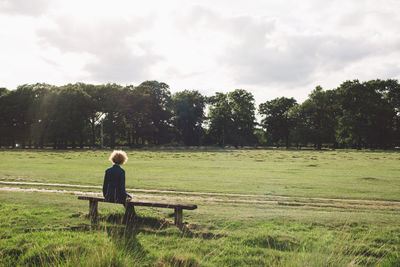 Woman on field against sky