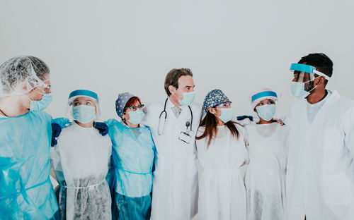 Doctors wearing mask standing against white background