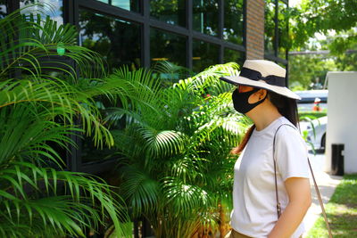 Side view of woman standing by plants