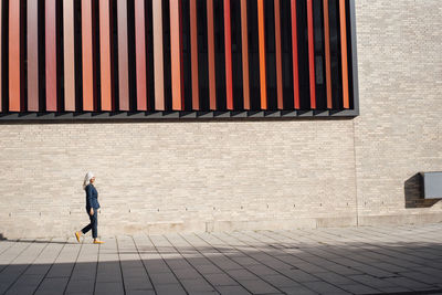 Businesswoman walking on footpath outside office building