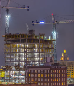 Illuminated buildings in city against sky at night