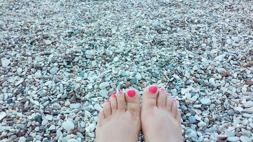 Low section of woman feet on pebbles