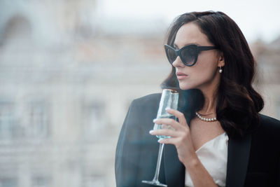 Young woman drinking glass with sunglasses