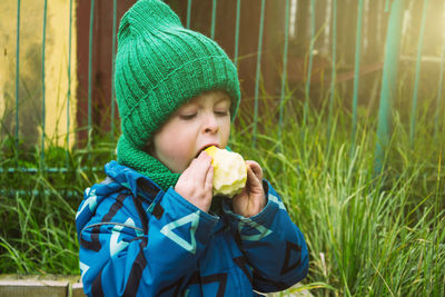 Child eating delicious apple outdoors, fruit snack. healthy food concept. vitamins in food