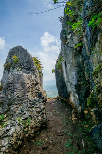 Rock formations by sea against sky