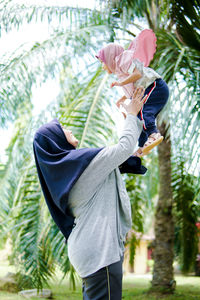 Rear view of woman standing against trees