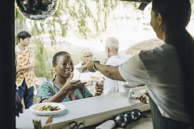 Female seller serving food to customer in park