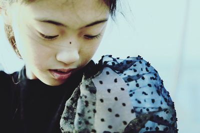 Close-up of girl looking down against wall