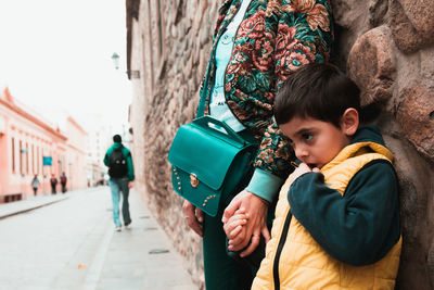 Midsection mother and son holding hands