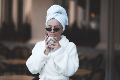Woman wearing bathrobe drinking coffee