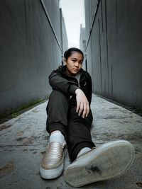 Portrait of woman sitting against wall