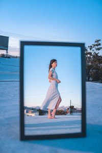 Woman standing against blue sky