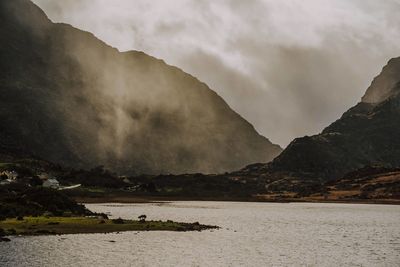 Scenic view of sea and mountains against sky