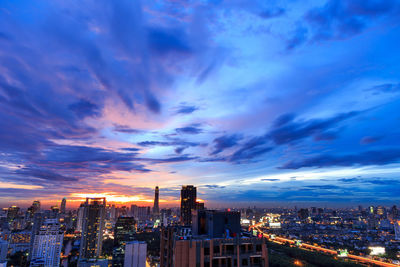 Aerial view of illuminated buildings against sky during sunset