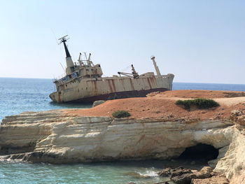 View of abandoned ship on sea against clear sky