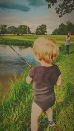 Rear view of boy looking at lake