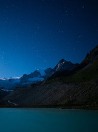 Scenic view of mountains against blue sky at night