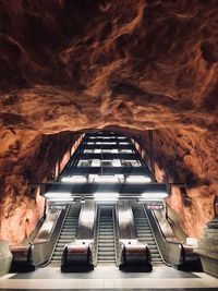 Low angle view of escalators in illuminated cave