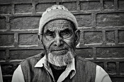 Portrait of senior man against brick wall