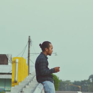 Man using mobile phone against clear sky