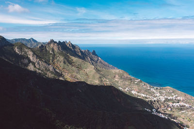 Scenic view of sea and mountains against sky