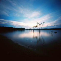 Scenic view of lake against sky at sunset