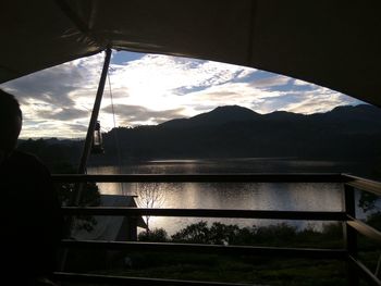 Man looking at lake seen through window