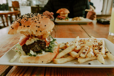 Close-up of burger and vegetables in plate on table