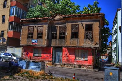 Houses by street in city against buildings