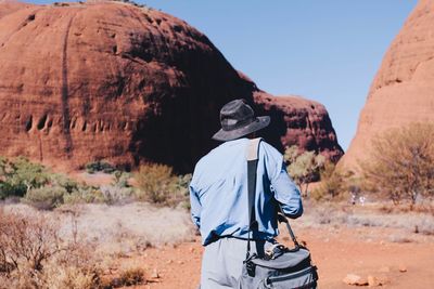 Rear view of woman standing on rock formation