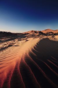 Scenic view of desert against clear blue sky