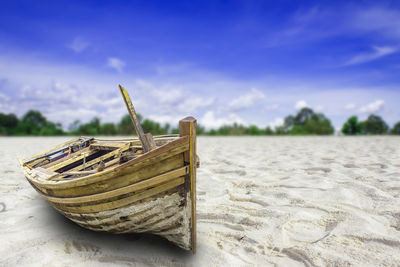 Close-up of deck chairs on beach against sky