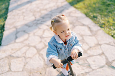 Portrait of boy riding bicycle on footpath