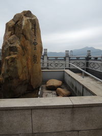 Text on rock against sky