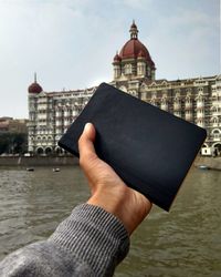 Close-up of man holding camera in city