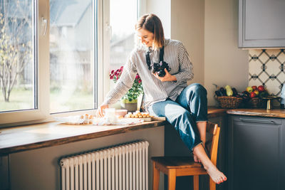 Side view of young woman sitting at home