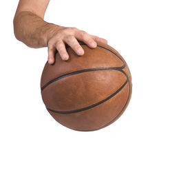 Low angle view of hand holding ball against white background