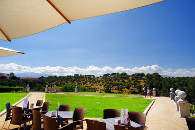 People relaxing on chairs against sky