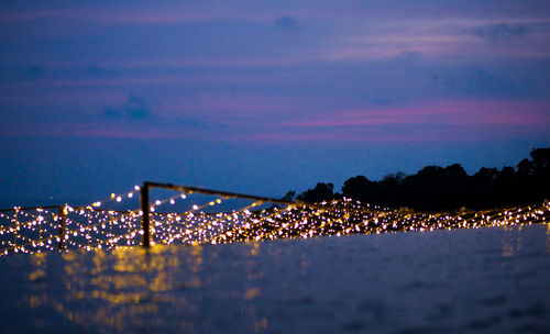 Illuminated city against sky at night