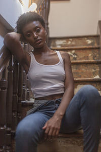 Portrait of a young woman sitting in a staircase