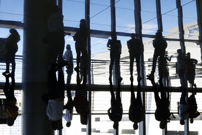 Reflection of men on water against sky