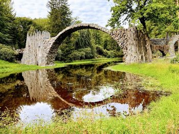 Arch bridge over lake against sky