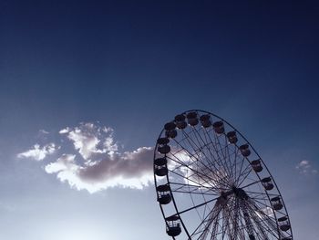 Low angle view of ferris wheel against blue sky