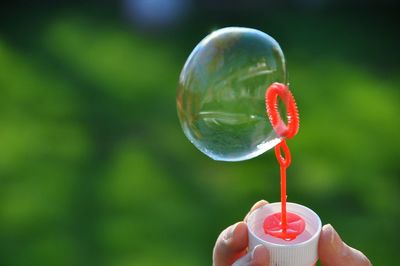 Cropped image of hand holding bubble wand