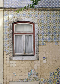 Slightly damaged and charming - building with tiles in lisbon, portugal