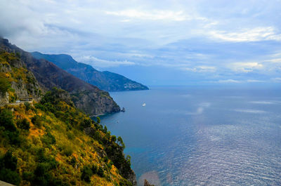 Scenic view of sea and mountains against sky